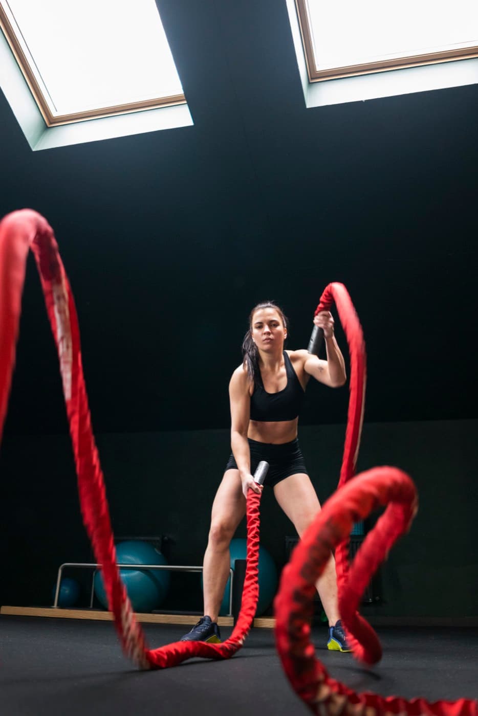 Atleta treinando com corda naval num box de CrossFit